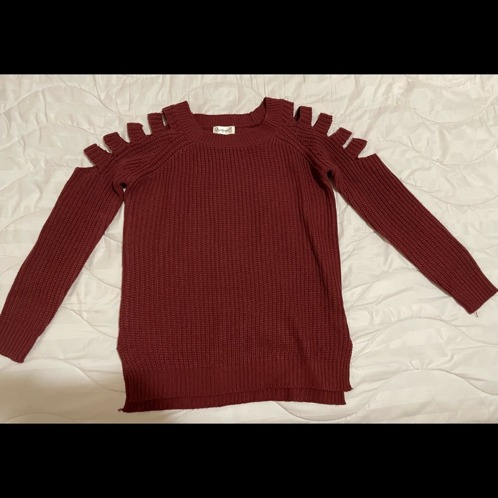 Dark burgundy sweater with shoulder cut sleeves and side slits.